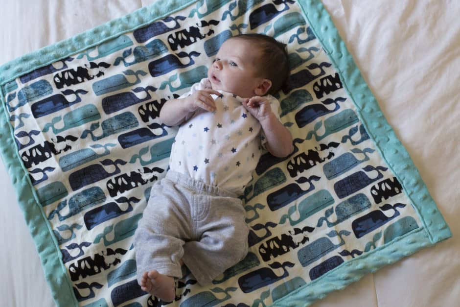 Looking for a baby blanket sewing pattern? This simple tutorial (and must-have new baby checklist) is perfect for any new mom or those of us looking to give the perfect gift! Read on for the full DIY sewing tutorial including the best fabric for a baby blanket (hint: minky is one of them!). Make an easy sew baby blanket in just a few minutes. Like to sew & quilt? This free and easy sewing project has got you covered.